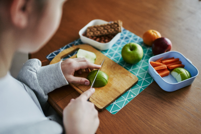 a person preparing a healthy snack of fruits and vegetables